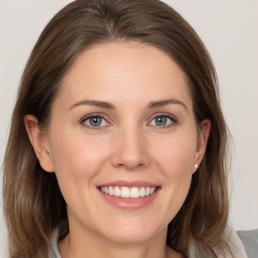 Joyful white young-adult female with medium  brown hair and grey eyes