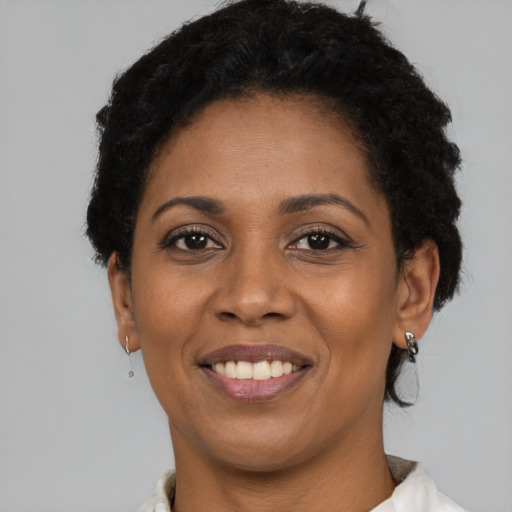 Joyful black young-adult female with short  brown hair and brown eyes