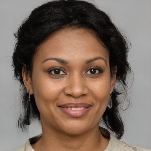 Joyful black adult female with medium  brown hair and brown eyes