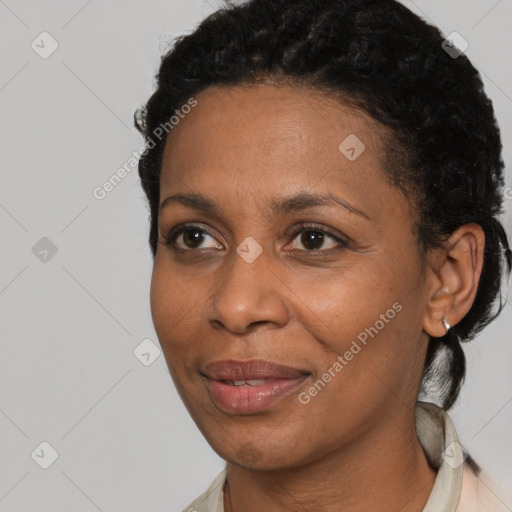 Joyful black adult female with short  black hair and brown eyes