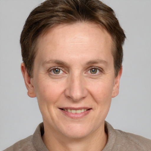 Joyful white adult female with short  brown hair and grey eyes