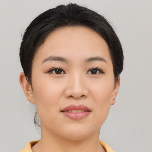 Joyful asian young-adult female with short  brown hair and brown eyes