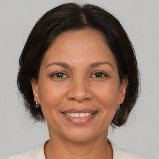 Joyful latino adult female with medium  brown hair and brown eyes