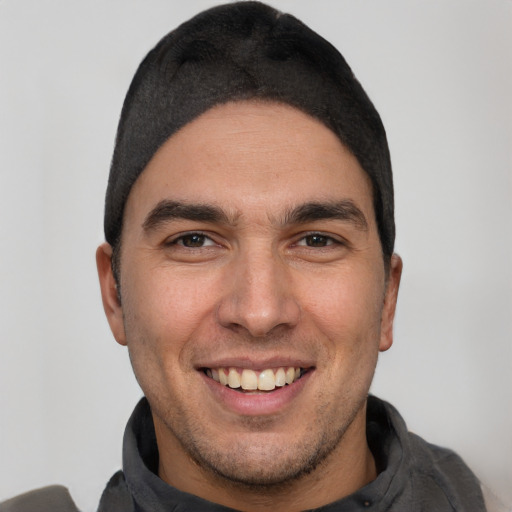 Joyful white young-adult male with short  black hair and brown eyes