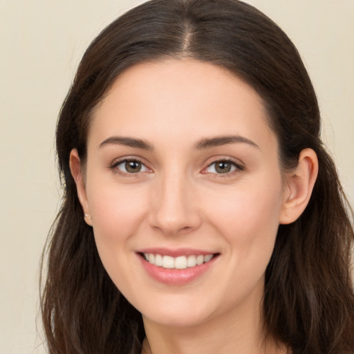 Joyful white young-adult female with long  brown hair and brown eyes