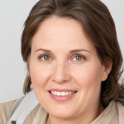 Joyful white adult female with medium  brown hair and grey eyes