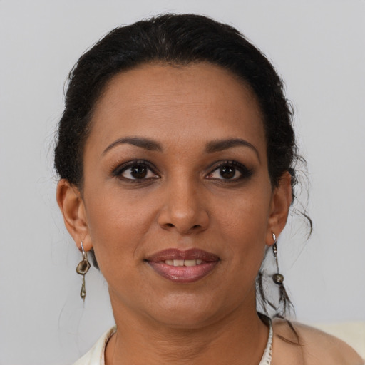 Joyful latino young-adult female with short  brown hair and brown eyes