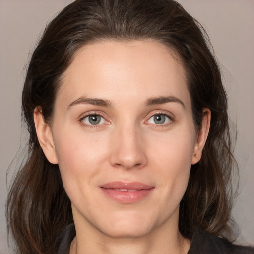 Joyful white young-adult female with medium  brown hair and grey eyes