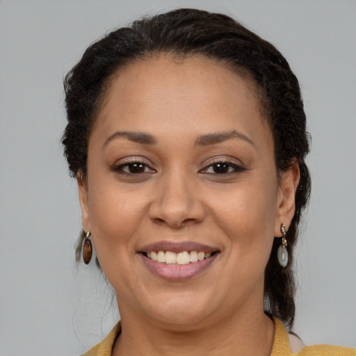 Joyful black adult female with medium  brown hair and brown eyes