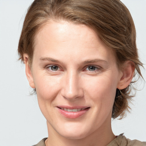 Joyful white young-adult female with medium  brown hair and grey eyes