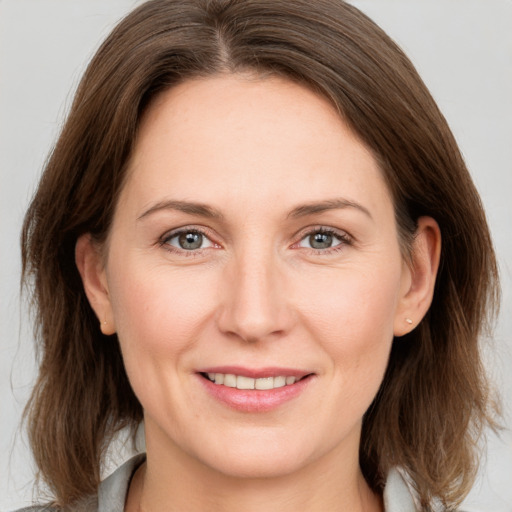 Joyful white adult female with medium  brown hair and grey eyes