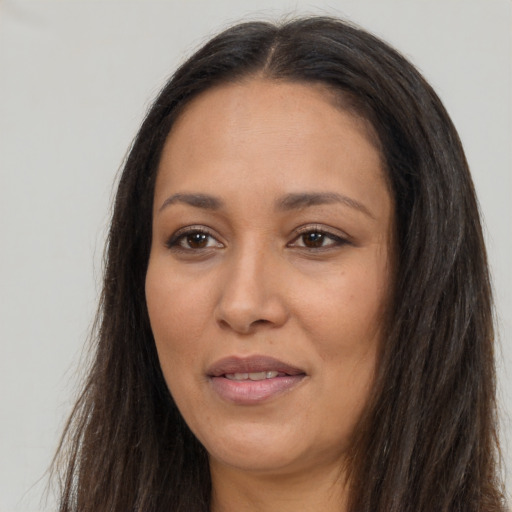 Joyful latino adult female with long  brown hair and brown eyes