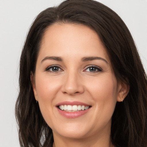 Joyful white young-adult female with long  brown hair and brown eyes