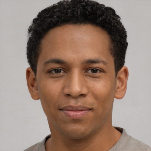 Joyful black young-adult male with short  black hair and brown eyes