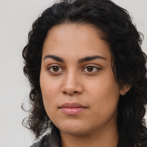 Joyful latino young-adult female with long  black hair and brown eyes