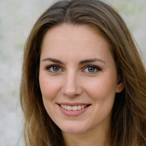 Joyful white young-adult female with long  brown hair and green eyes