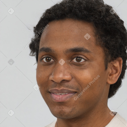 Joyful black young-adult male with short  black hair and brown eyes