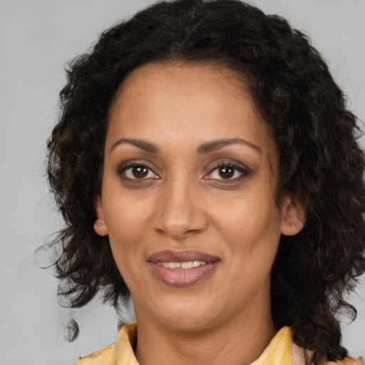 Joyful black adult female with medium  brown hair and brown eyes