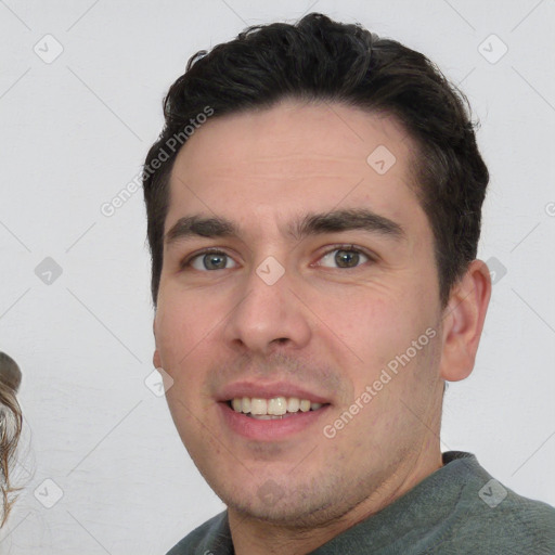 Joyful white young-adult male with short  black hair and brown eyes