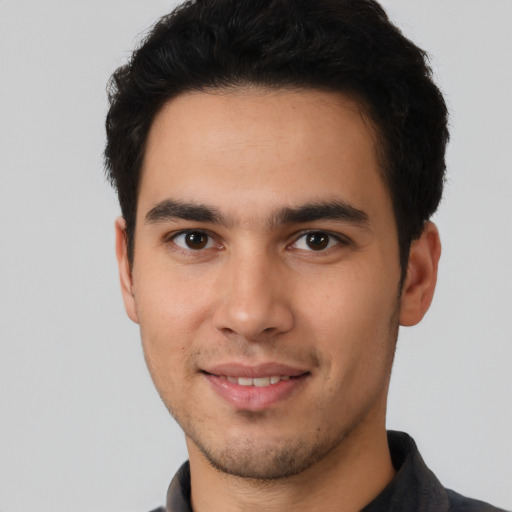 Joyful white young-adult male with short  black hair and brown eyes