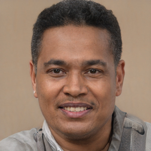 Joyful latino adult male with short  black hair and brown eyes
