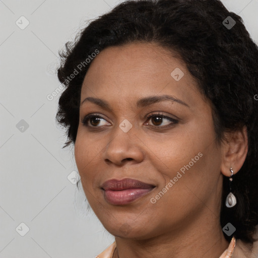 Joyful black adult female with long  brown hair and brown eyes