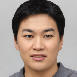 Joyful asian young-adult male with short  black hair and brown eyes