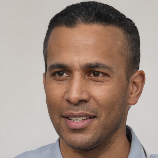 Joyful latino adult male with short  black hair and brown eyes