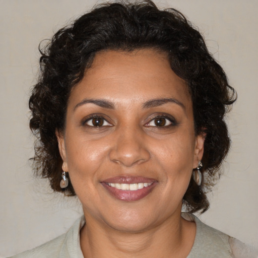Joyful black adult female with medium  brown hair and brown eyes