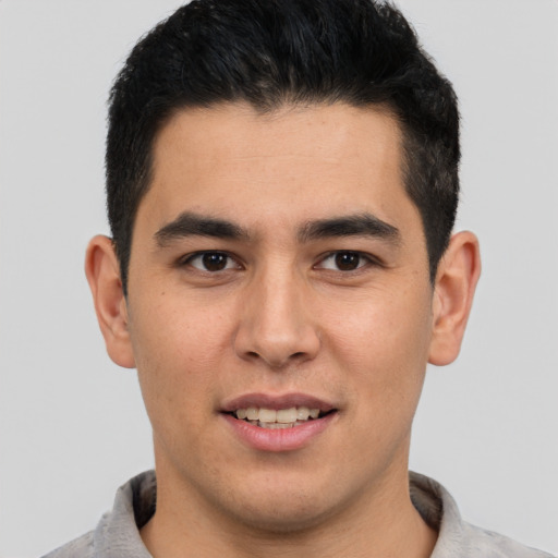 Joyful latino young-adult male with short  brown hair and brown eyes