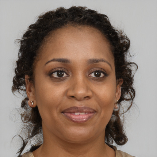 Joyful black adult female with medium  brown hair and brown eyes