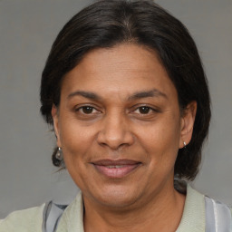 Joyful black adult female with medium  brown hair and brown eyes