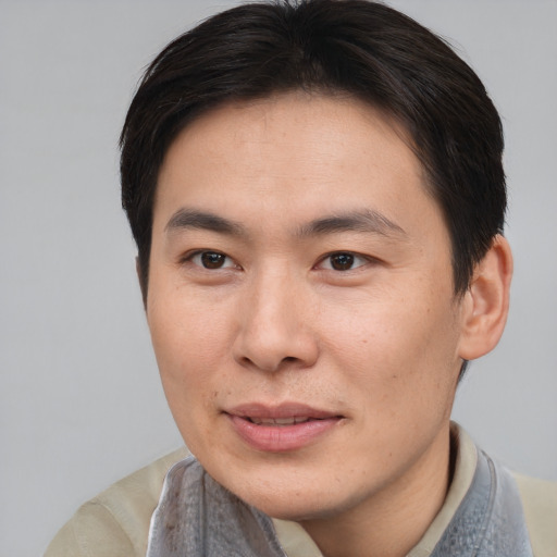 Joyful asian young-adult male with short  brown hair and brown eyes
