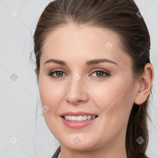 Joyful white young-adult female with medium  brown hair and grey eyes