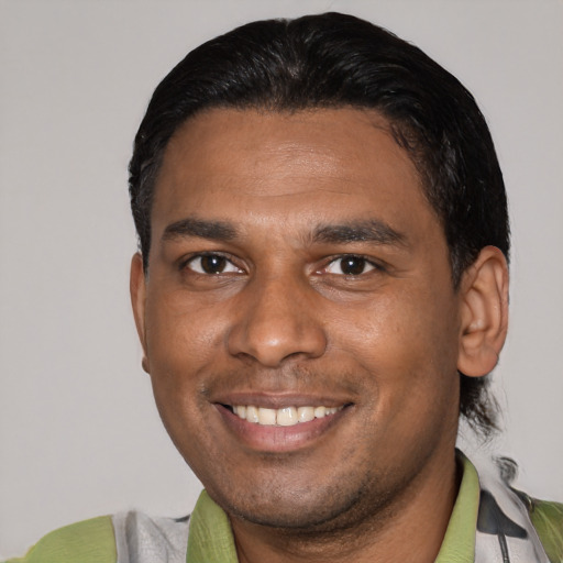 Joyful latino young-adult male with short  black hair and brown eyes