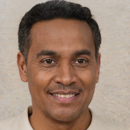 Joyful black adult male with short  brown hair and brown eyes