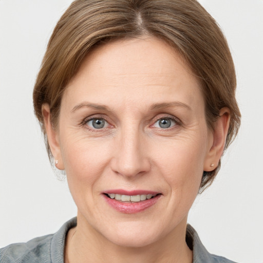 Joyful white adult female with medium  brown hair and grey eyes