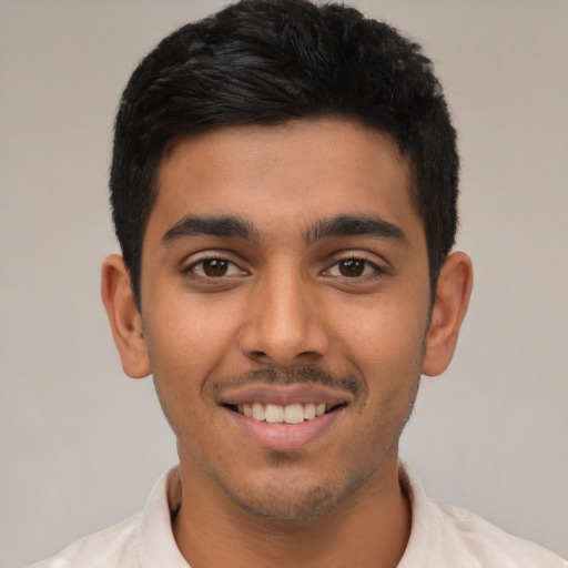 Joyful latino young-adult male with short  brown hair and brown eyes