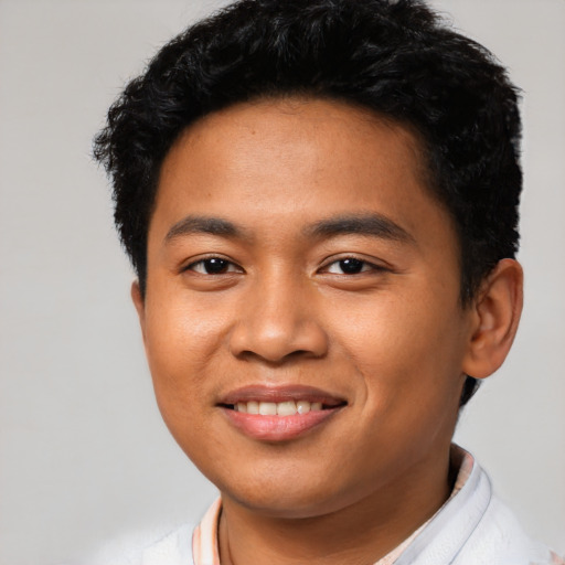 Joyful latino young-adult male with short  black hair and brown eyes