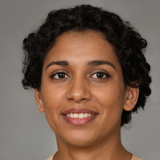 Joyful black adult female with short  brown hair and brown eyes