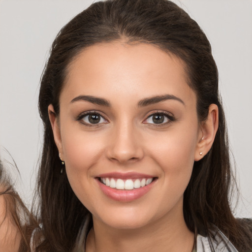 Joyful white young-adult female with long  brown hair and brown eyes