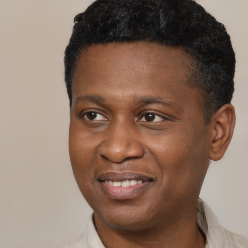 Joyful black young-adult male with short  black hair and brown eyes