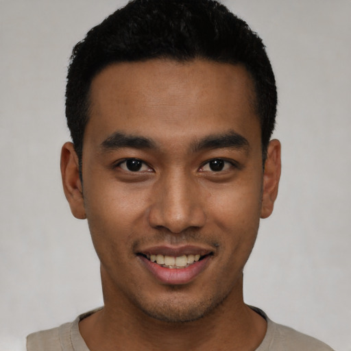 Joyful latino young-adult male with short  black hair and brown eyes