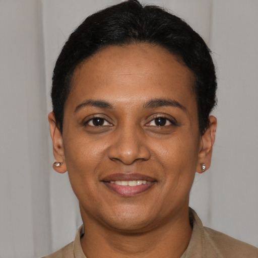 Joyful black young-adult female with short  black hair and brown eyes