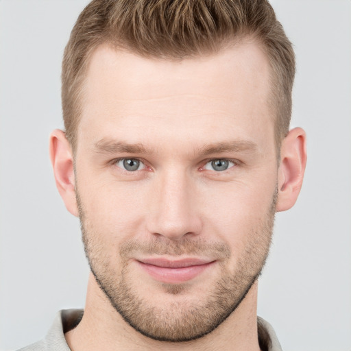 Joyful white young-adult male with short  brown hair and grey eyes