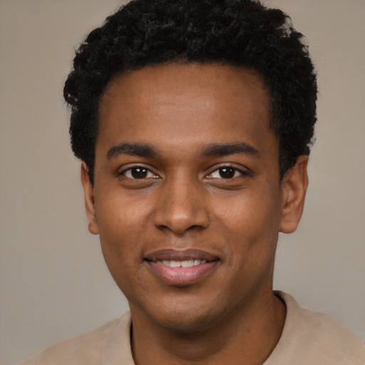 Joyful black young-adult male with short  black hair and brown eyes