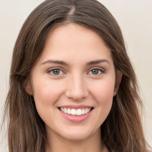 Joyful white young-adult female with long  brown hair and grey eyes