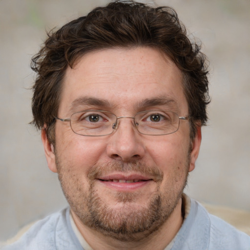 Joyful white adult male with short  brown hair and blue eyes