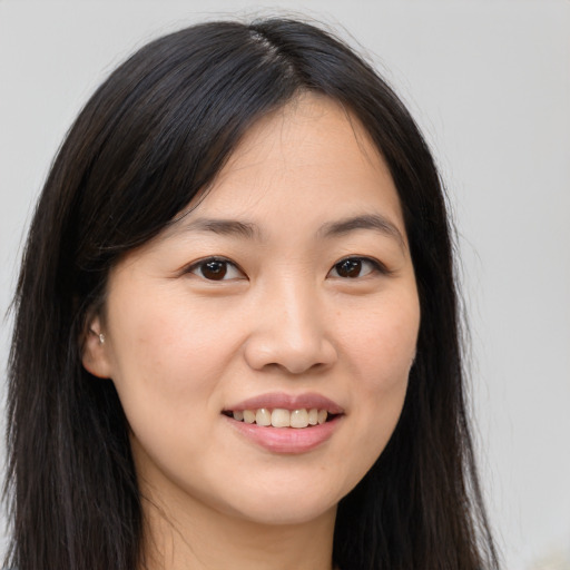 Joyful asian young-adult female with long  brown hair and brown eyes