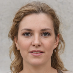 Joyful white young-adult female with medium  brown hair and grey eyes